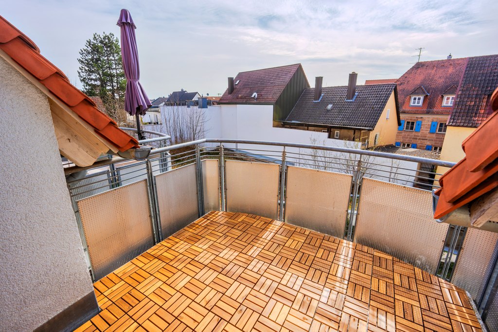 Balkon mit Holzdielen und Blick über die Dächer