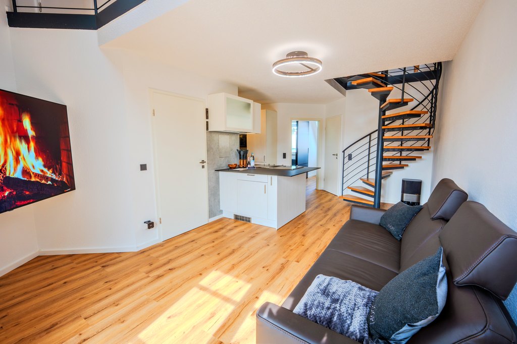 Heller Wohnbereich einer Maisonette-Wohnung mit Wendeltreppe und Holzboden